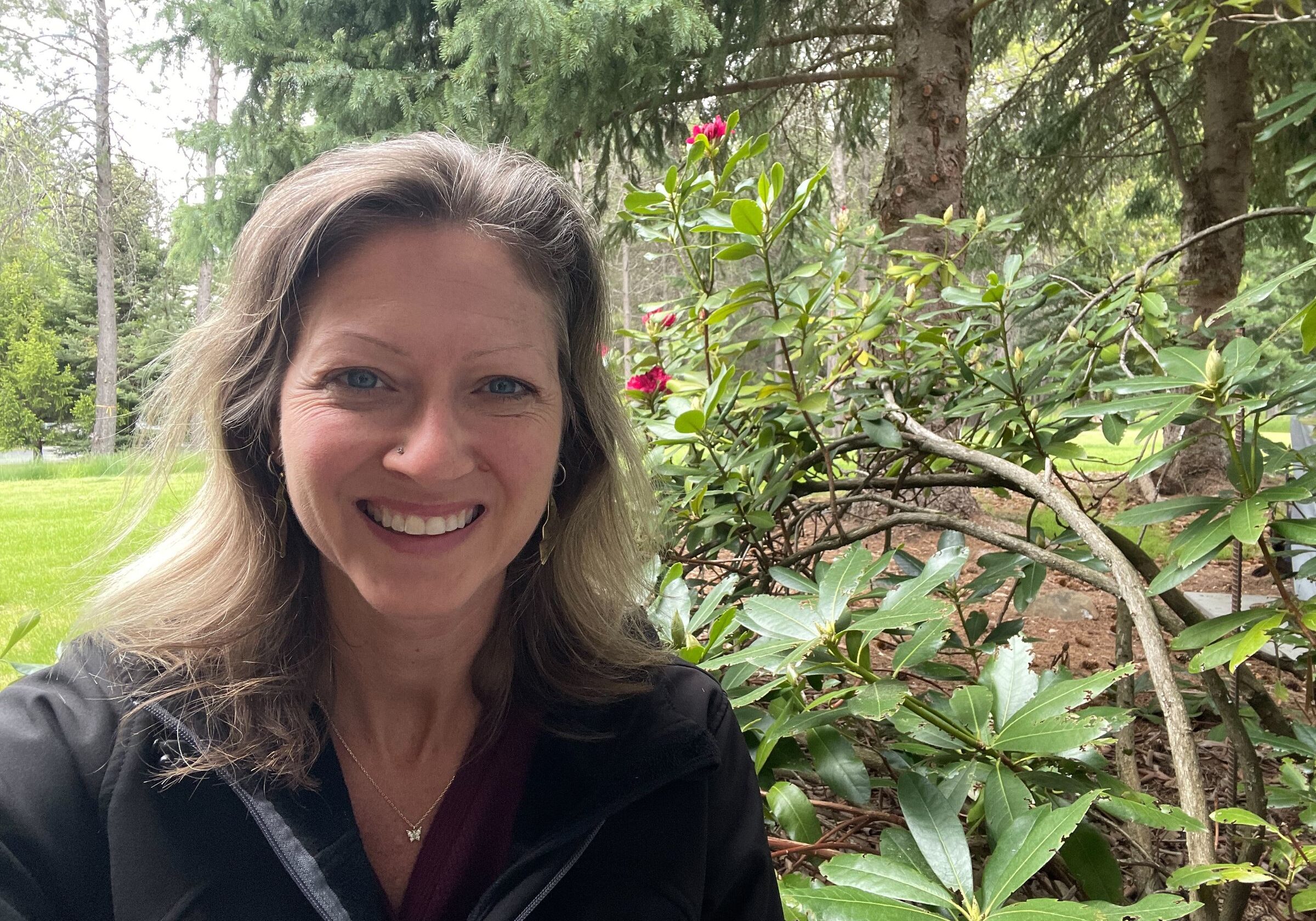 Emily in front of a rhododendron bush.